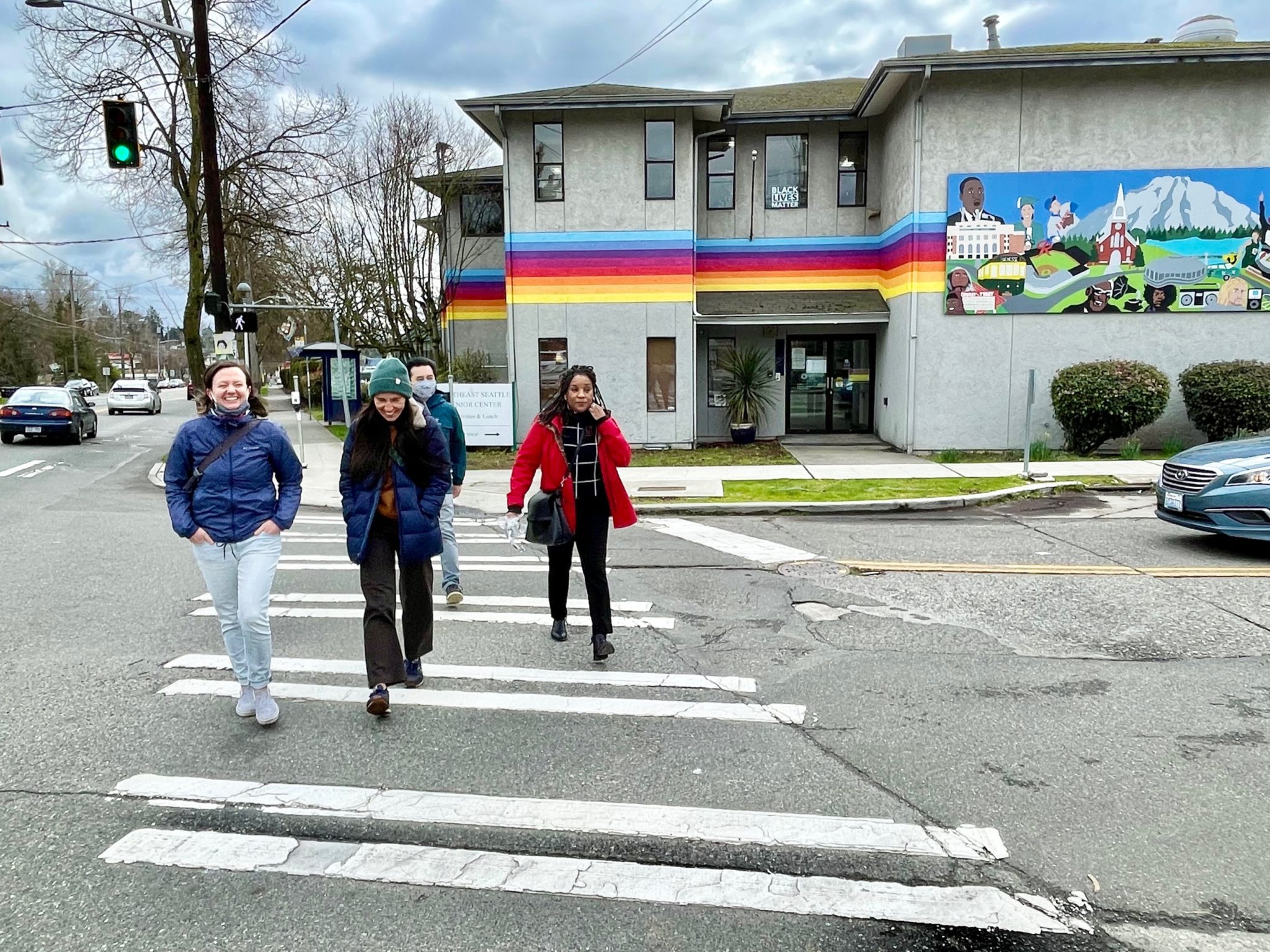 Four people cross a street in Rainier Valley.