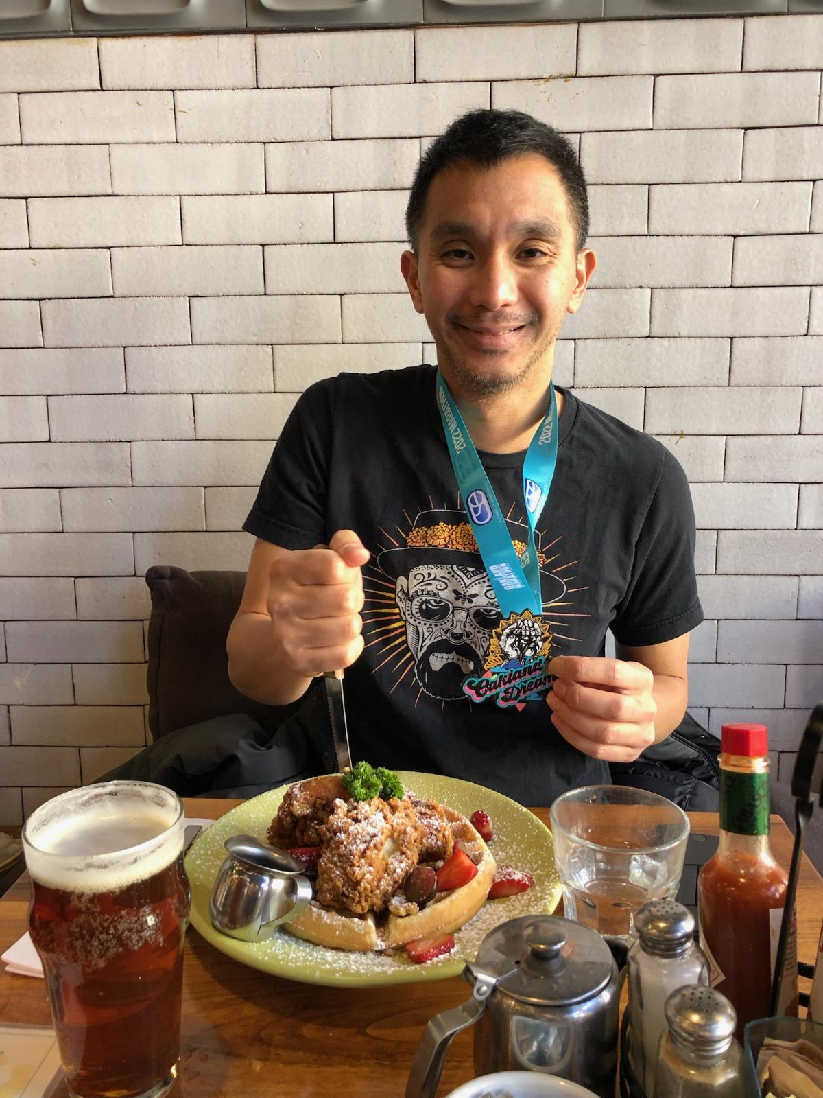 Fred enjoys a plate of chicken and waffles after completing the Oakland Marathon in California earlier this year.