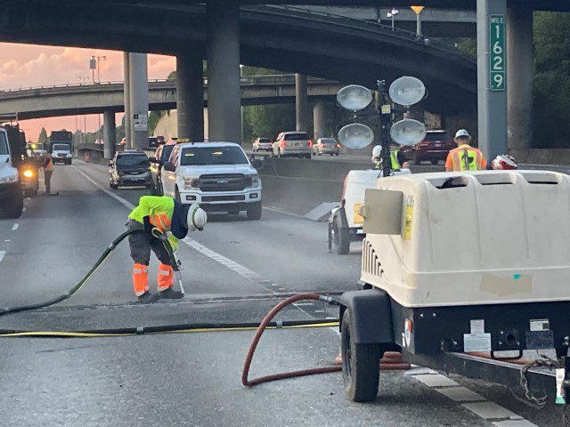 Crews work on the expansion joints on I-5 during a past weekend closure. Several workers stand on the highway in a section that is closed to traffic.
