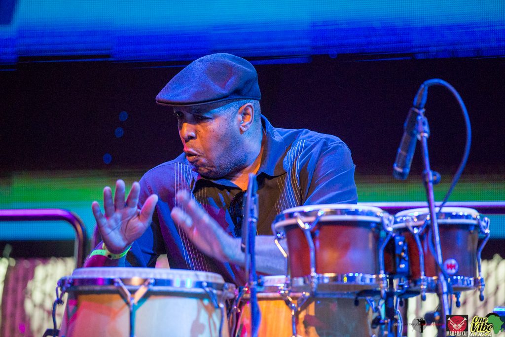 A man wearing a hat plays the drums at a past festival.