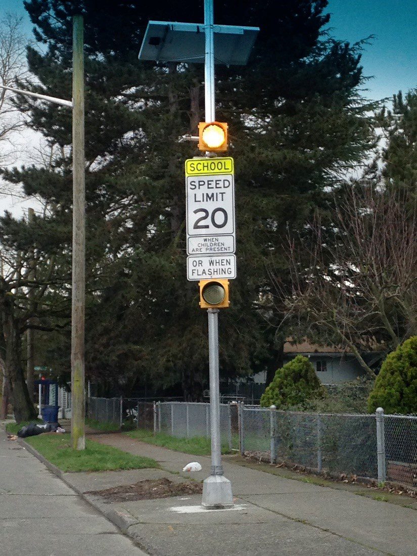 A flashing beacon sign that reads "School. Speed Limit 20. When children are present or when flashing"
