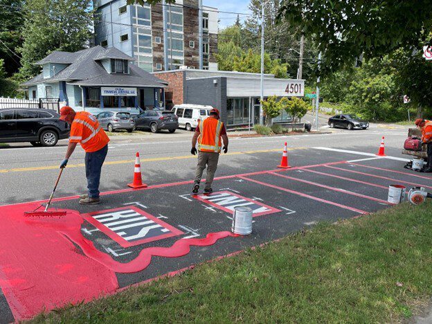 SDOT painting new red bus lanes. 