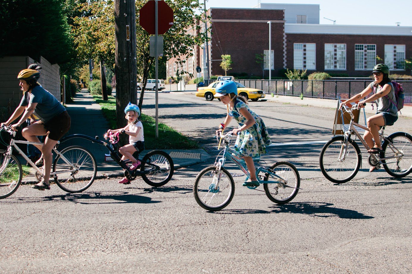 Several adults and children bike during a Summer Parkways event in the Central District.