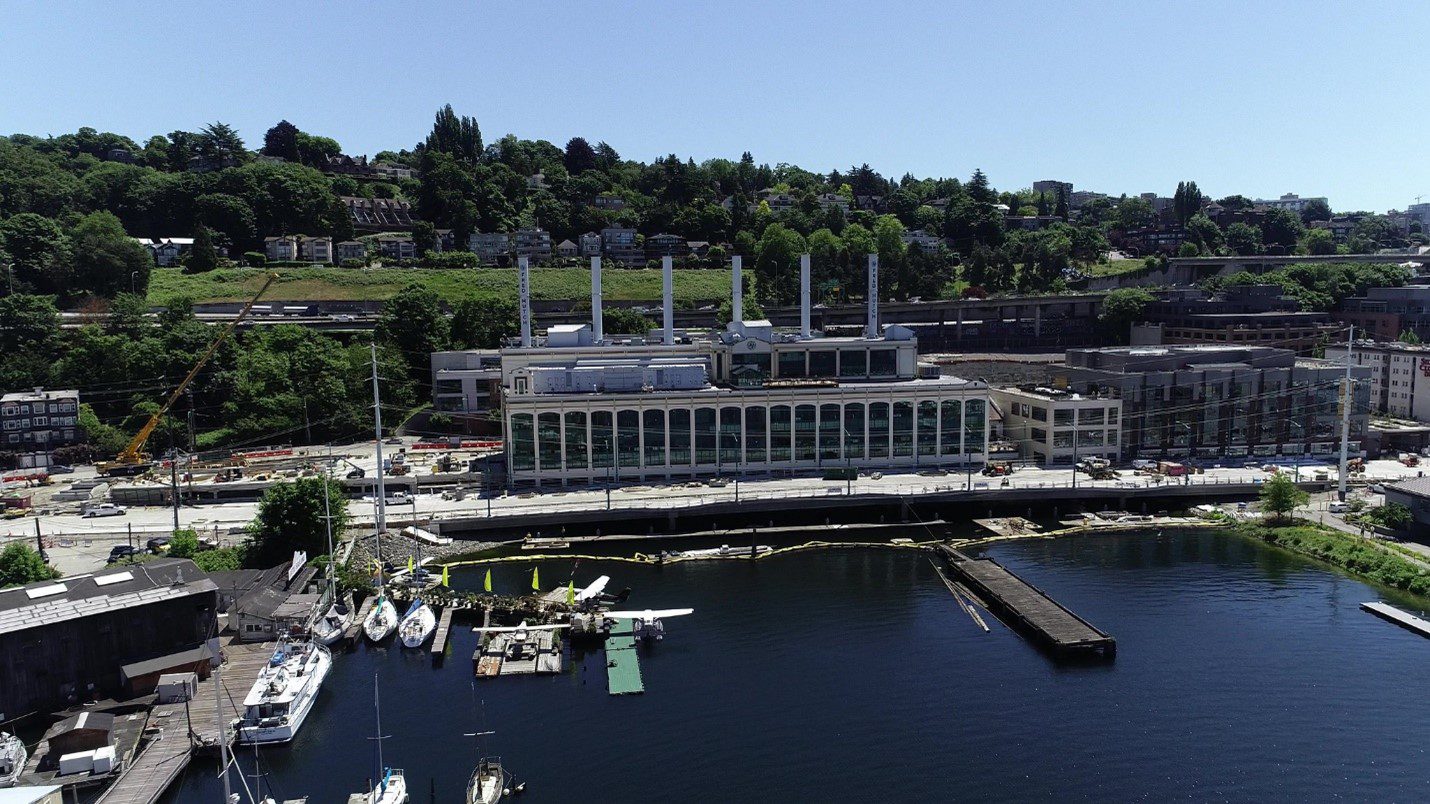 Aerial photo of large buildings, trees, boats, and street.