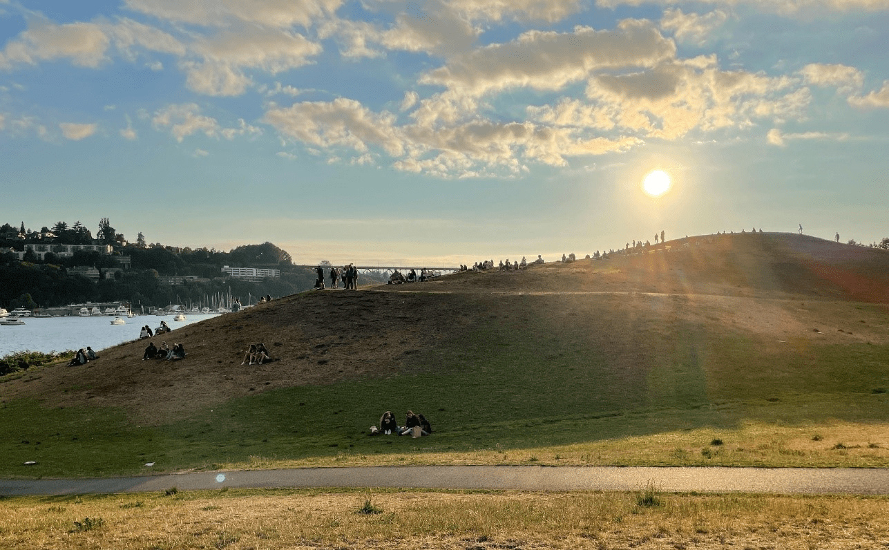 Golden hour at Gas Works Park, facing west, with the sun setting behind Kite Hill