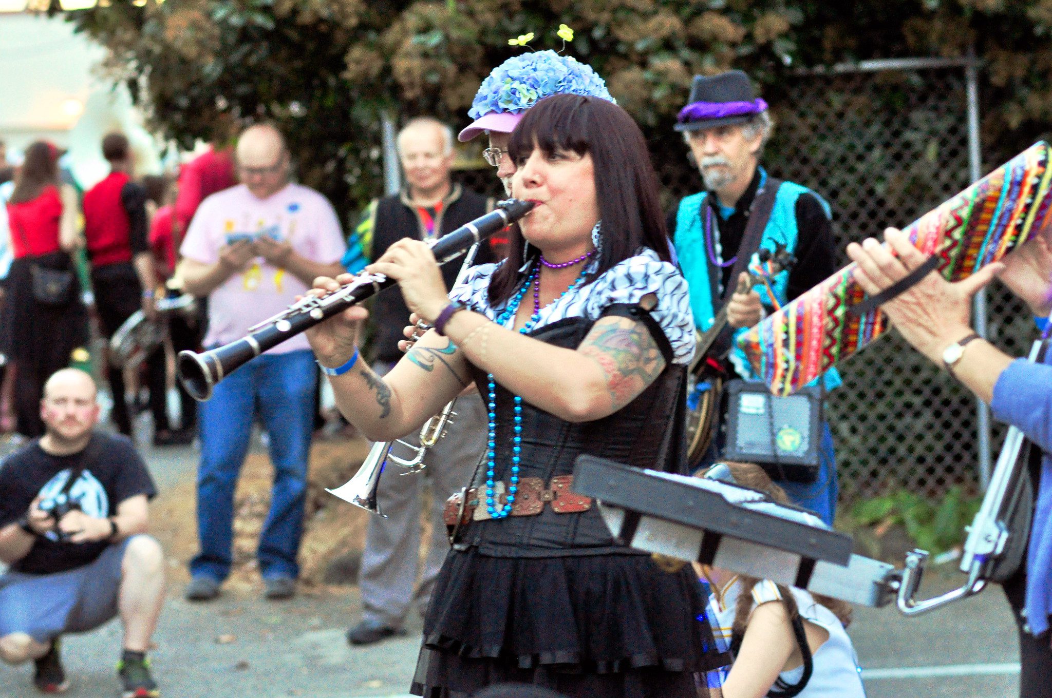A woman and several other musicians play music at an outdoor community event.