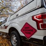 A white truck parked under trees and next to leaves. An orange logo says "SDOT Response Team" in black lettering on the side of the truck.