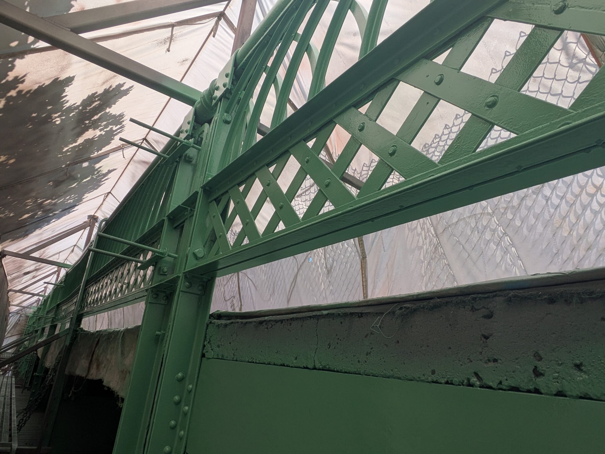 A section of a bridge with darker green paint.