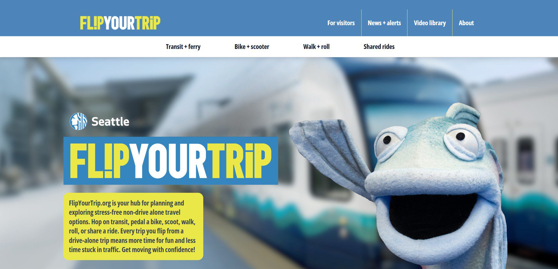 A screenshot of the Flip Your Trip website featuring a blue and white navigation bar with options like "Transit + ferry" and "Bike + scooter." The main section shows a blurred light rail train in the background, a quirky fish puppet on the right, and a bold "FL!PYOURTRiP" logo with a yellow text box promoting stress-free travel options. The design uses bright blue and yellow colors.