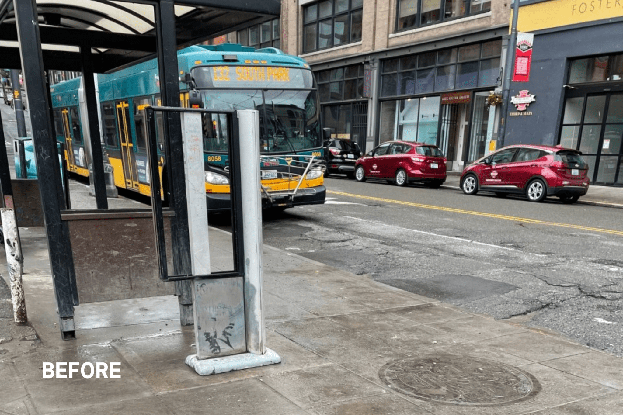 A city bus is stopped along a badly damaged street with cracks and holes. Several cars are parked behind it and storefronts line the block. In the foreground, an empty, weathered sign frame. A “before” label suggests this photo documents the area prior to street or transit improvements.