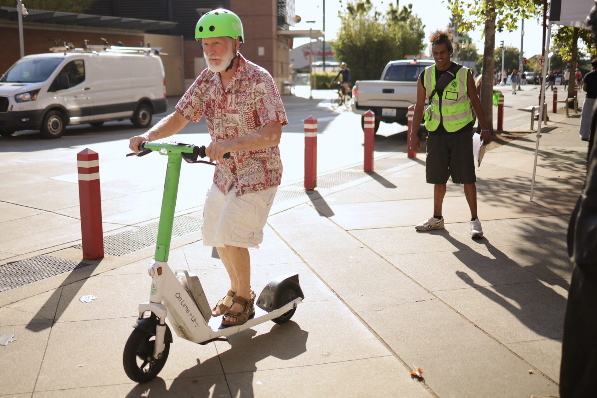 A person in a colorful shirt receives instructions on how to ride a scooter safely at an SDOT event.