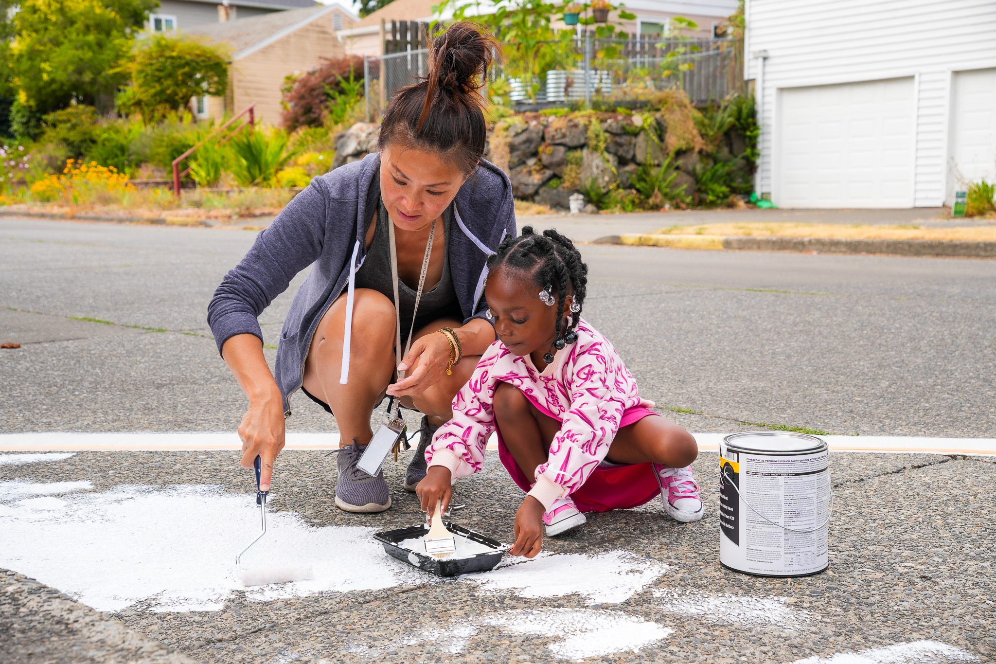 Two people paint on the street.