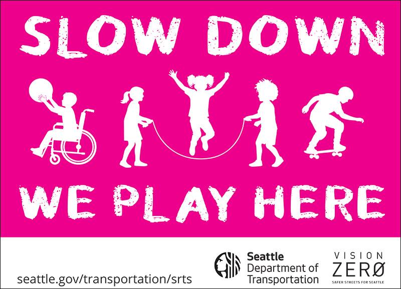 A pink and white yard sign that says Slow Down, We Play Here. It has the SDOT logo, Vision Zero logo, and an SDOT web link to seattle.gov/transportation/srts.
