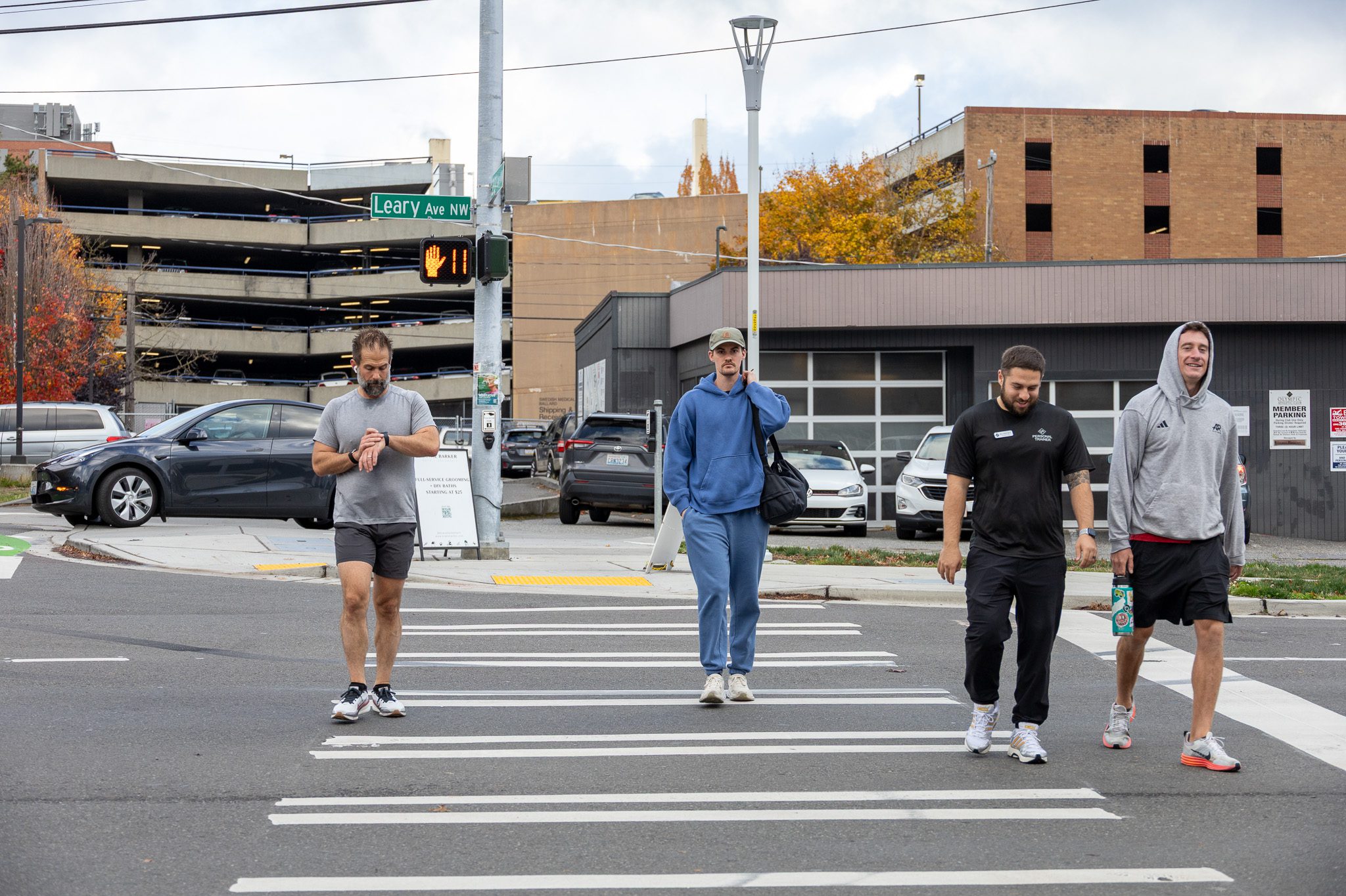 Four people cross the street at a marked crosswalk.